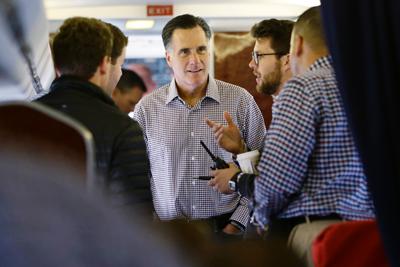 Republican presidential candidate Mitt Romney talks with campaign trip director Charlie Pearce, second from right, after boarding his campaign plane in Sterling, Va., Thursday. 