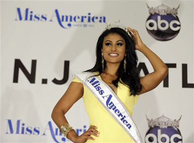 FILE - In this Sunday, Sept. 15, 2013 file photo, Miss America Nina Davuluri poses for photographers following her crowning in Atlantic City, N.J. For some who observe the progress of people of color in the U.S., Davaluris victory in the Miss America pageant shows that Indian-Americans can become icons even in parts of mainstream American culture that once seemed closed. (AP Photo/Mel Evans)