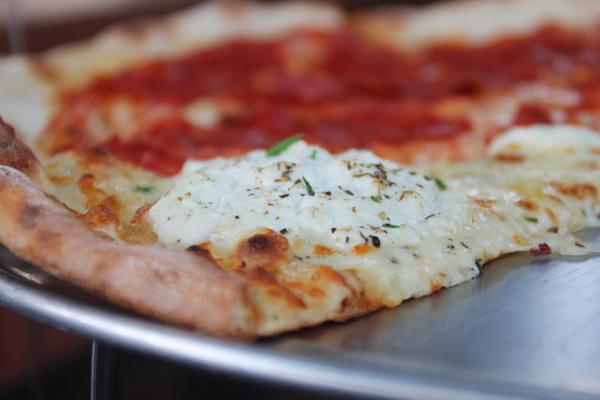 Zoli’s white pizza: thin, crispy crust perfectly charred and topped with ricotta and mozzarella cheese, loaded with garlic and sprinkled with spicy red pepper flakes. (CHRISTOPHER SAUL/The Daily Campus)