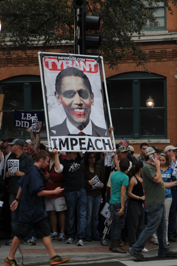 Protestors hold up “Impeach Obama” signs from Alex Jones’s website Infowars.com during Friday’s commemoration. (RYAN MILLER / The Daily Campus)