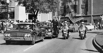 ADVANCE FOR USE SUNDAY, NOV. 17, 2013 AND THEREAFTER - FILE - In this Friday, Nov. 22, 1963 file photo, seen through the foreground convertibles windshield, President John F. Kennedys hand reaches toward his head within seconds of being fatally shot as first lady Jacqueline Kennedy holds his forearm as the motorcade proceeds along Elm Street past the Texas School Book Depository in Dallas. Gov. John Connally was also shot. (AP Photo/James W. Ike Altgens)