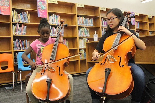 First-year Rachel Gan teaches a student how to play the cello. Photo credit: Sue Han