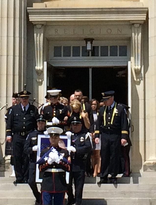 Officers lead the family of Officer McCuller down the stairs of McFarlin Auditorium for the military honors ceremony. Photo credit: Jacquelyn Elias