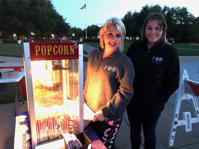 Mollie Mayfield (left) and Amanda Taft (right) posing by the popcorn station at the Gamma Phi Beta Under the Crescent Moon movie night. Photo credit: Cynthia Mclaughlin