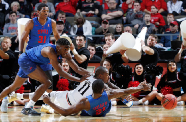 Gary Clark #11 of the Cincinnati Bearcats goes to the floor for a loose ball against Ben Emelogu II #21 and Shake Milton #1 of the SMU Mustangs in the second half of a game at BB&T Arena on January 7, 2018 in Highland Heights, Kentucky. Cincinnati won 76-56. Photo credit: Getty Images