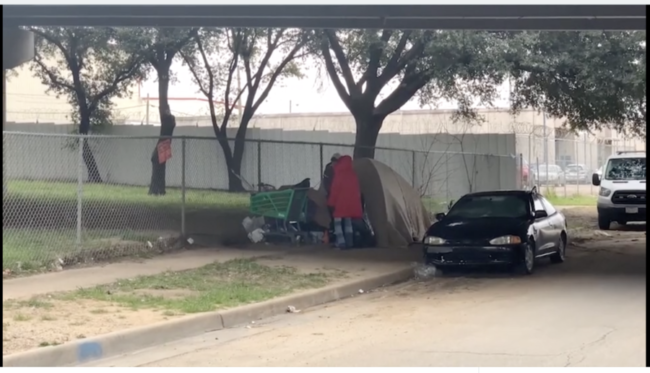 Two homeless people camp under a bridge in Dallas.