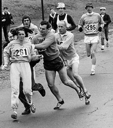 Kathrine Switzer, in famous bib number 261, is pushed in protest to her being a female running the marathon.