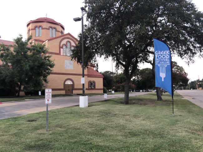 The banner for the Greek Food Festival of Dallas waves outside the Holy Trinity Greek Orthodox Church in Dallas, Texas. Photo credit: Shaye Galen