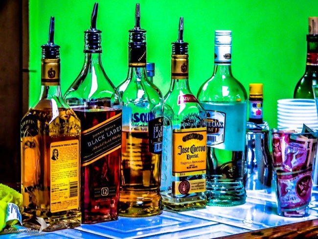 Different types of alcohol placed on a bar. Photo credit: Flickr