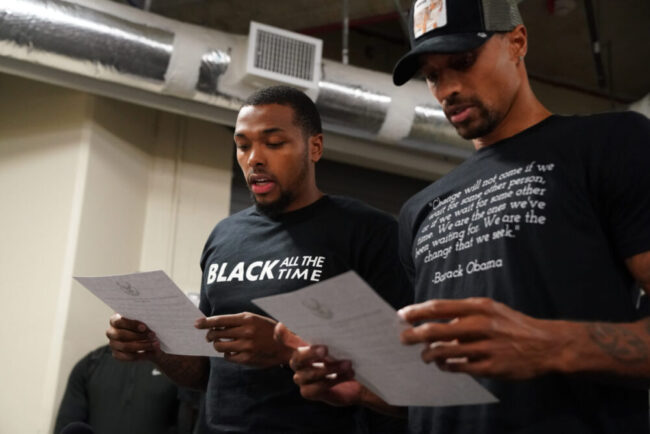 ORLANDO, FL - AUGUST 26: Sterling Brown and George Hill of the Milwaukee Bucks reads a statement to the media on August 26, 2020 at AdventHealth Arena at ESPN Wide World of Sports Complex in Orlando, Florida.