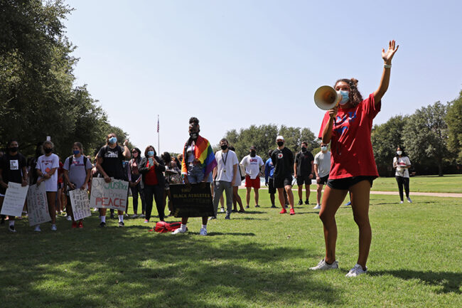 Ashton Woods speaks in front of the crowd before they start their march around campus. Photo credit: Ash Thye