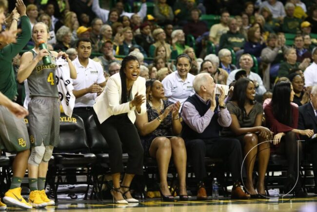 Wilson stands and cheers on the bench. Courtesy of Baylor Athletics.