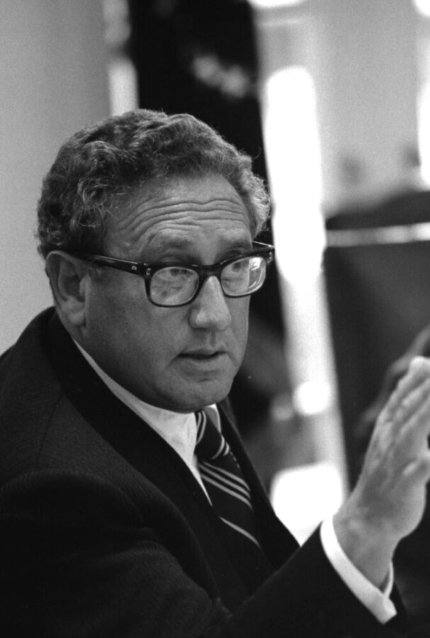 Black and white photo of Henry Kissinger with his hand pointed at someone.