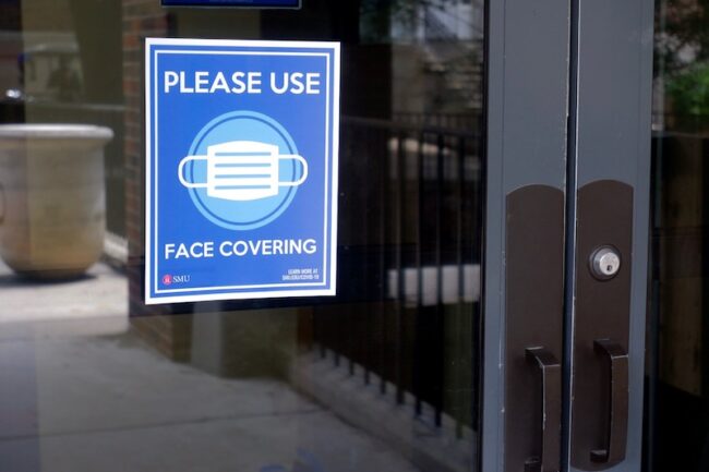 A poster on the door of the Hughes-Trigg student center asks people to wear a face covering. Photo credit: Audrey McClure