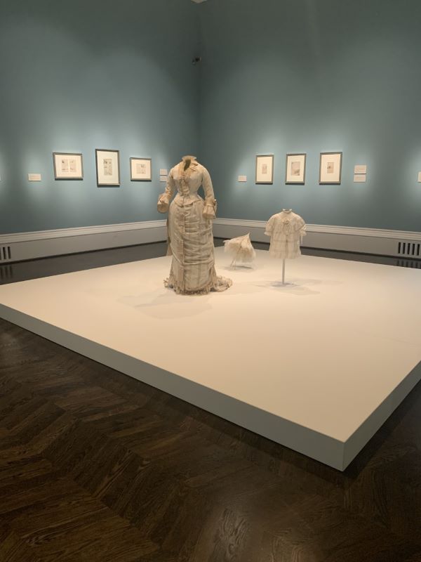 The dress and parasol are a part of the “Stepping Out” portion of the exhibit and display what people wore in public in 19th century Europe.