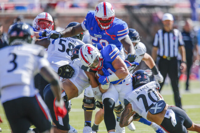 SMU player surrounded by three Cincinnati players during an NCAA football game at Ford Stadium on Saturday, Oct. 22, 2022 in University Park, Texas. Cincinnati defeated SMU 29-27. (Mark Reese / Photographer)