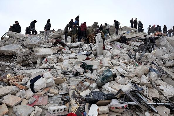 Residents and rescuers search for victims and survivors amidst the rubble of collapsed buildings following an earthquake in the village of Besnaya in Syrias rebel-held northwestern Idlib province on the border with Turkey, on February 6, 2023. - At least 1,293 people were killed and 3,411 injured across Syria today in an earthquake that had its epicentre in southwestern Turkey, the government and rescuers said. (Photo by OMAR HAJ KADOUR / AFP) (Photo by OMAR HAJ KADOUR/AFP via Getty Images) Photo credit: Getty Images