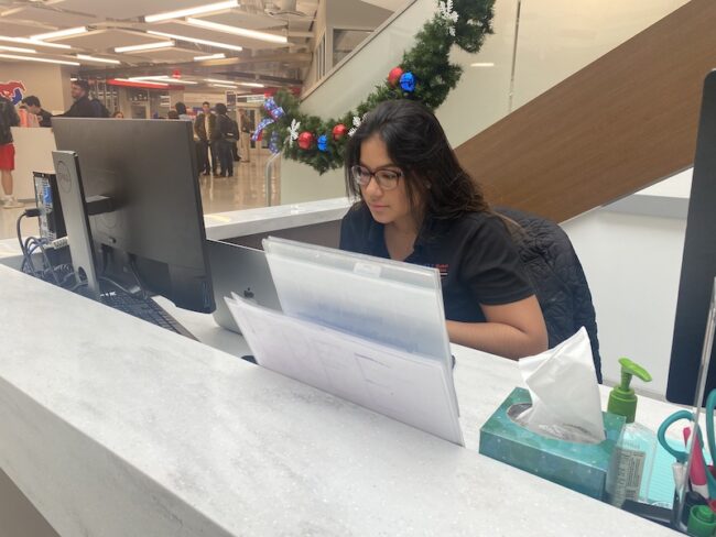 Cabral works hard while sitting at the Hughes-Trigg Welcome Desk. Photo credit: Caleigh Daugherty