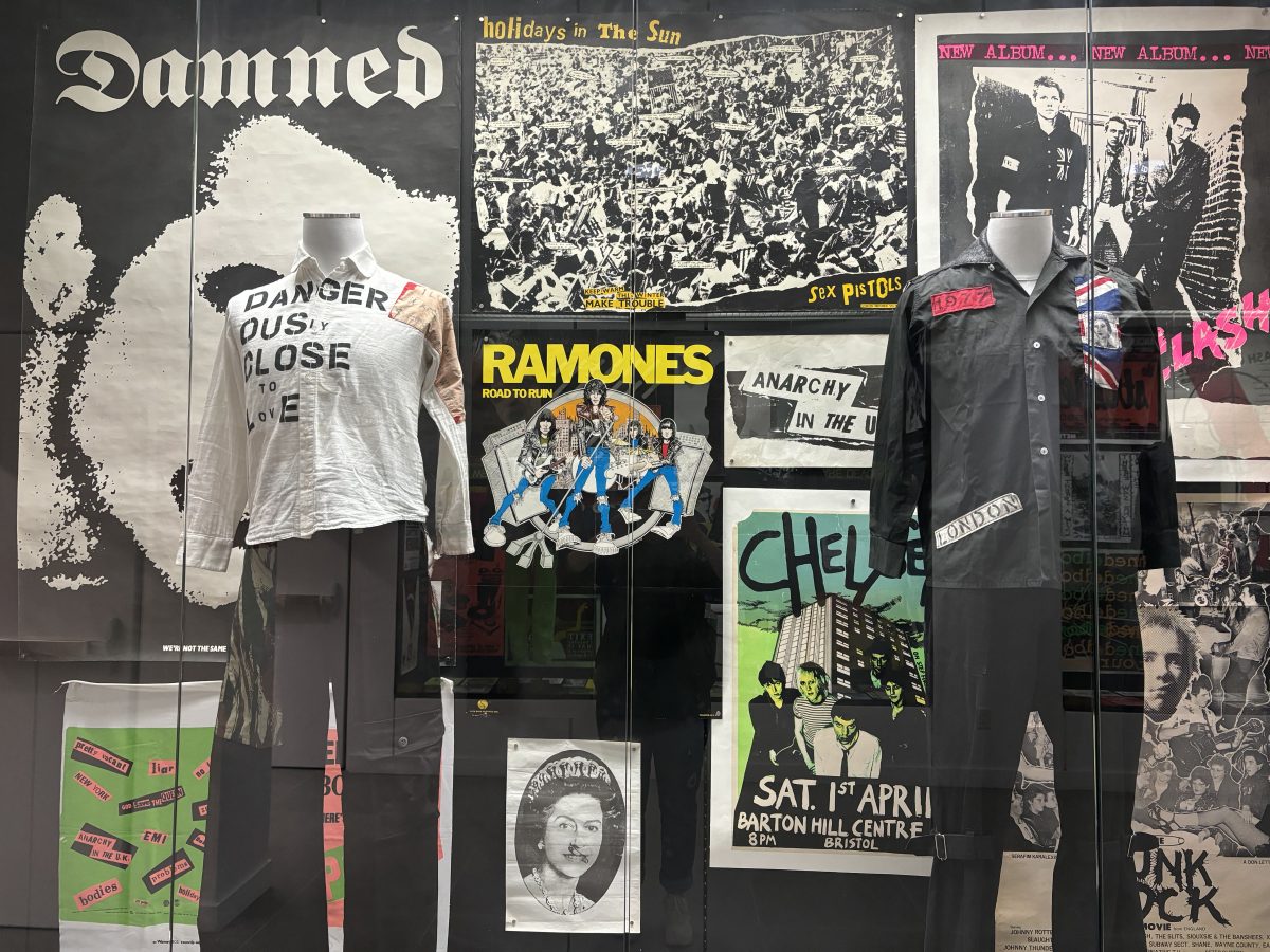 Glass encasing of outfits worn by punk bands and famous designers like Vivienne Westwood line the hall to the exhibit.