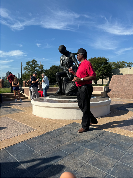 Tour guide, Don Pinkard, sharing history in front of a statue at Freedman’s Cemetery.