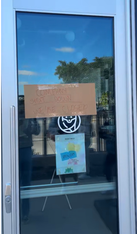 Photo shows a piece of cardboard taped to the front door of Foxtrot in Snider Plaza. The sign reads, “Company shut down. we’re closed.”