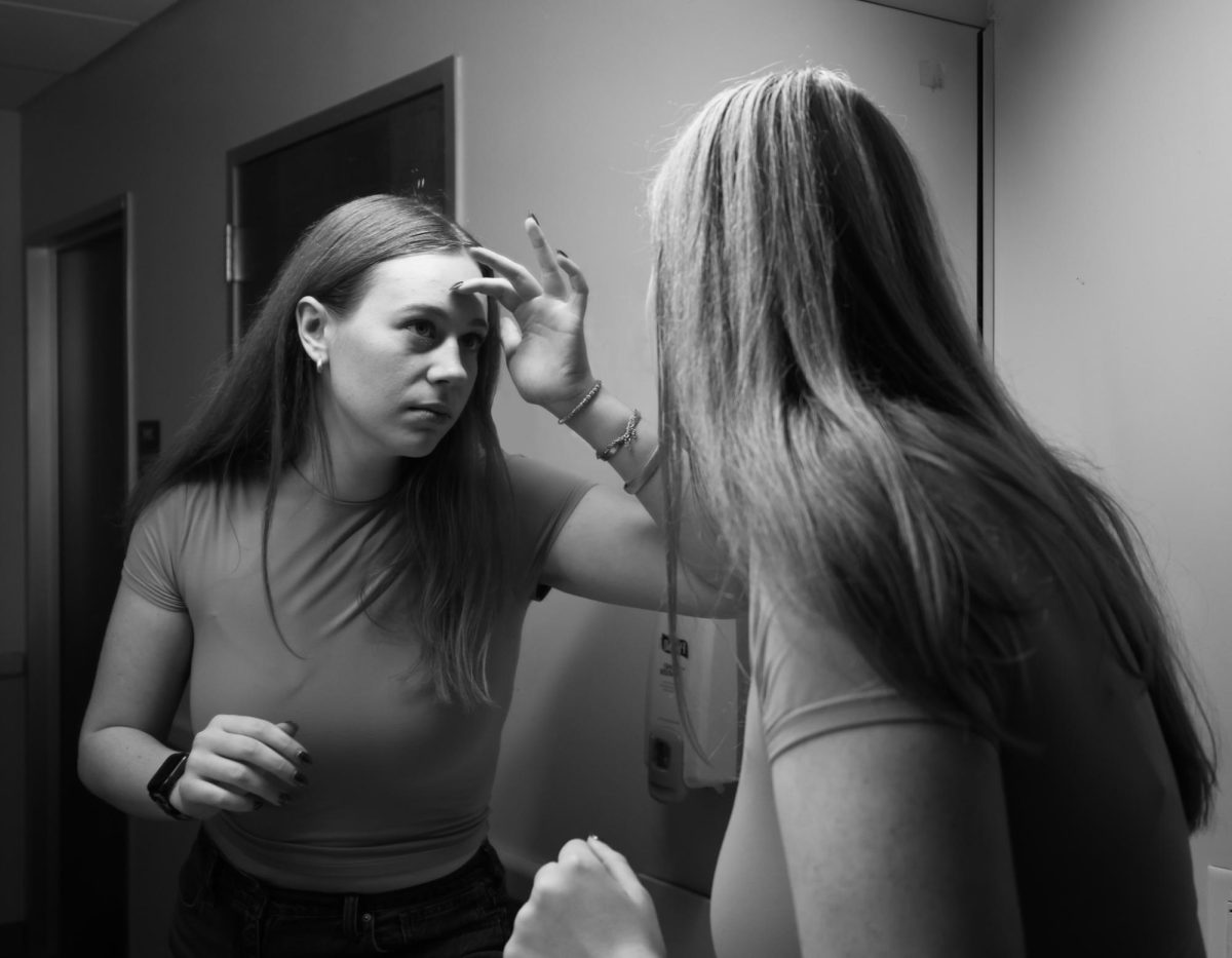 Junior Ella Skelsey looks at her reflection in the mirror.