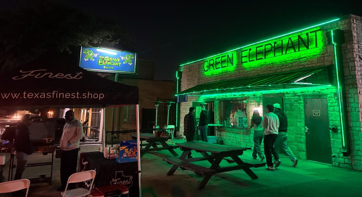 The ‘Green Elephant’ neon sign shines brightly on the exterior of the bar as SMU upperclassmen line up outside waiting to enter the bar in Dallas, Texas, on Feb. 12, 2026. (Chloe Casdorph)