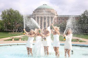 SMU seniors get together with friends to take graduation pictures at the most iconic places on campus, like the top of the Boulevard, Dallas Hall and in the Dallas Hall fountain in Dallas, Texas, on April 17, 2026.