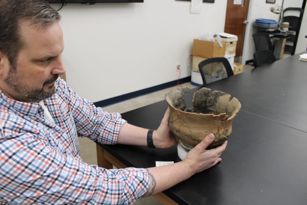 Matthew Boulanger, Ph.D., director of the Archaeology Research Collections, holds a pot that was excavated in the 1960s by the Texas Archaeological Society at a site near Lake Fork Reservoir, East of Dallas.