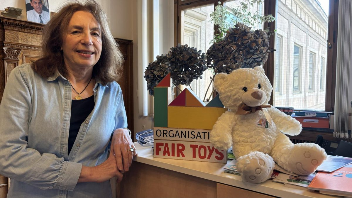 Pictured is the human rights educator in Nuremberg: Helga Riedl. She
stands next to a teddy bear and toy blocks that read “FAIR TOYS,” an organization that promotes sustainability. 